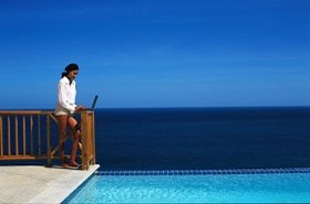 Woman with Laptop by the Pool and Ocean